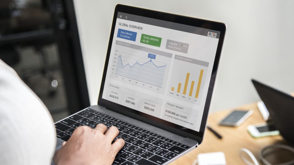 Person analyzing paid ad performance on a laptop dashboard showing sales metrics, campaign goals, and Bidding strategies.