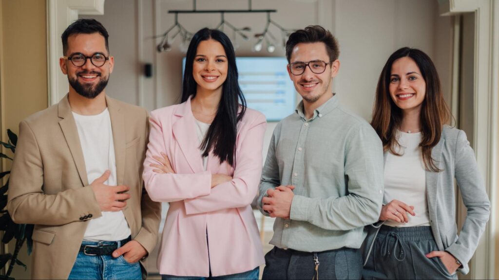 Group of young professionals at a Florida marketing agency posing in a modern office setting