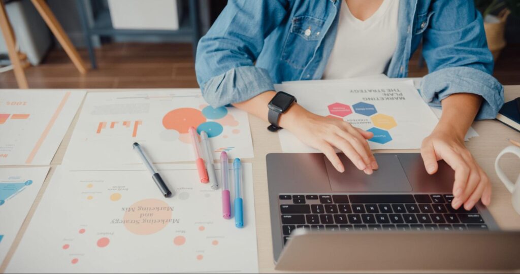 Marketer analyzing AI-driven campaign performance and content strategy on a laptop.